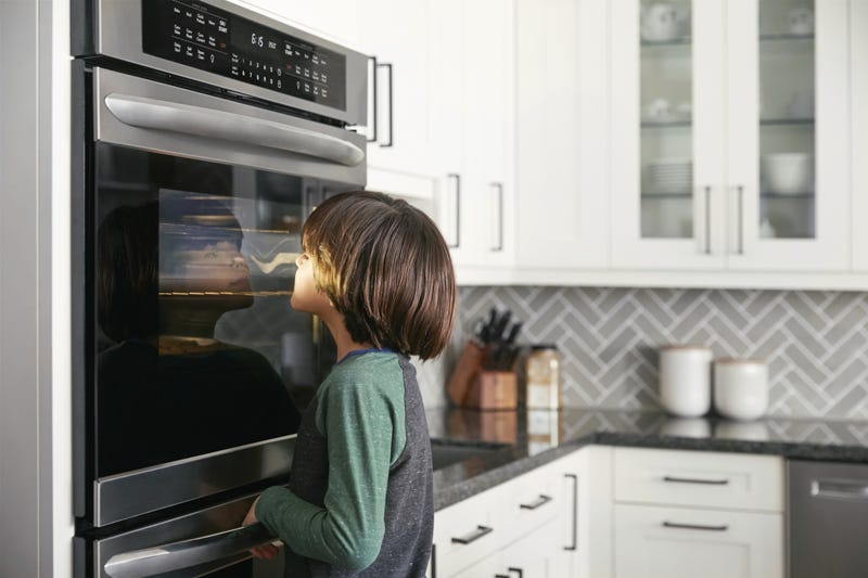 Boy looking in to a wall oven
